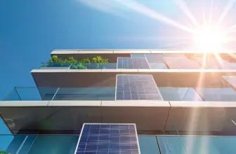 The modern apartment building features multiple balconies with solar panels attached for generating green energy